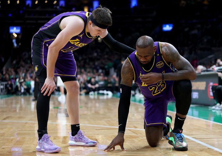 Austin Reaves ræðir við LeBron James sem gat ekki klárað leikinn gegn Boston Celtics.