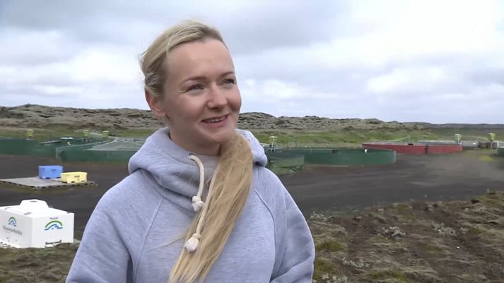 Anna Magdalena Buda er rekstrarstjóri Klausturbleikju á Kirkjubæjarklaustri. Hér er hún við eldisstöðina á Teygingalæk í jaðri Brunahrauns, sem sést fyrir aftan.