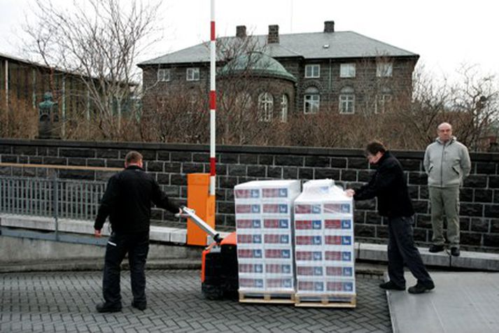 Starfsmenn Prentsmiðjunnar Odda trilla skýrslunni inn í Alþingishúsið undir vökulum augum óeinkennisklædds lögreglumanns. Mynd/ GVA.