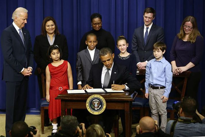 Obama Bandaríkjaforseti skrifaði undir 23 tilskipanir sem hann getur látið koma í kring. Börn sem skrifuðu honum bréf og báðu hann að herða byssulöggjöfina eftir Sandy Hook-árásina í desember voru með honum á sviðinu. fréttablaðið/ap