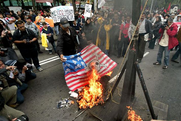 Mótmælendur brenndu heimagerðan bandarískan fána sem var með hauskúpur í stað stjarna í Mexíkó­borg í gær.