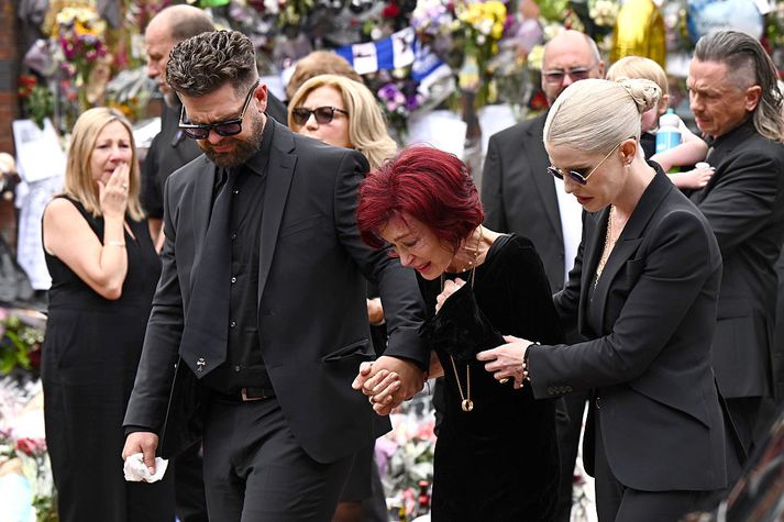 Börn Ozzy Osbourne, Jack og Kelly, hugga ekkju hans, Sharon Osbourne, í Birmingham í dag.