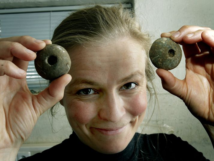 Birna Lárusdóttir með tvo af þeim fjórum snældusnúðum sem hafa fundist í uppgreftrinum.