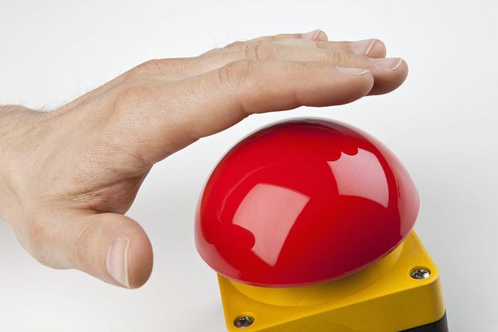 A hand about to press a big red buzzer Rauður hnappur