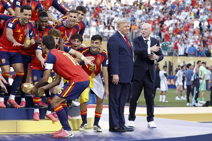 Gianni Infantino, forseti FIFA, reynir að fá Donald Trump Bandaríkjaforseta til að fara til hliðar áður en Rodri lyfti heimsbikarnum. Trump var með á flestum myndum en það lítur út fyrir að FIFA og spænska sambandið hafi hreinlega klippt hann út.