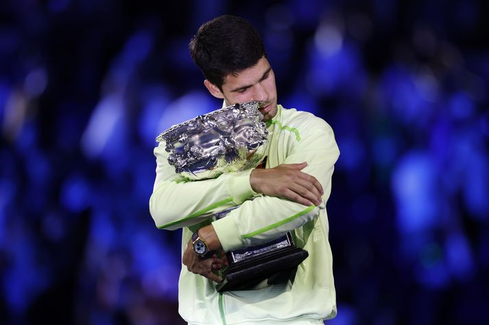 Carlos Alcaraz faðmar bikarinn eftir sigurinn á Opna ástralska meistaramótinu.