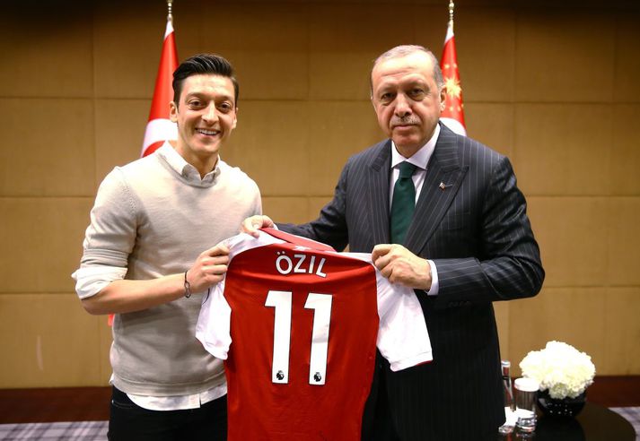 Özil skælbrosandi með forsetanum umdeilda.