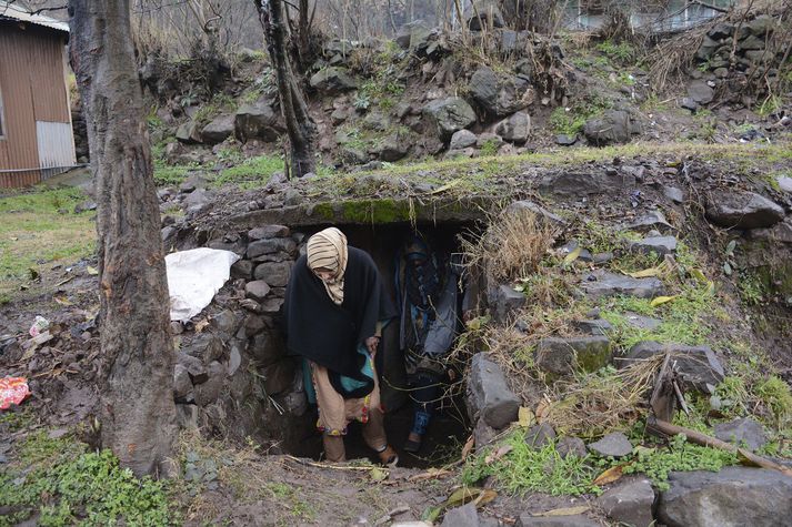 Íbúar yfirgefa heimagert sprengjuskýli í Chakoti nærri landamærum Pakistan og Indlands í Kasmír.