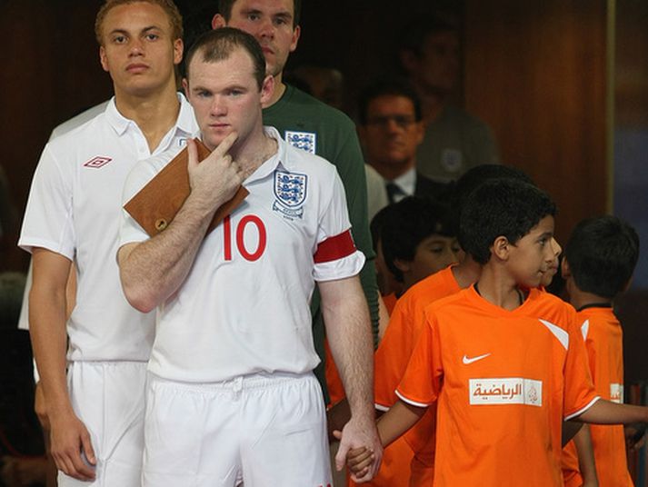 Wayne Rooney leiðir hér enska liðið inn á völlinn og Fabio Capello sést í bakgrunninum.