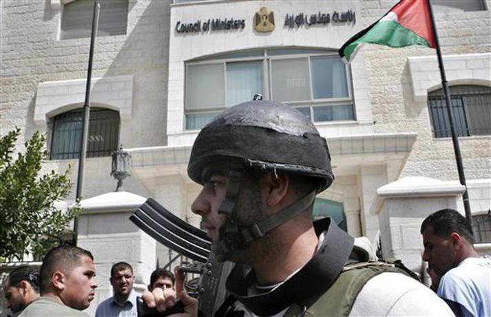 Vopnaður Palestínumaður fyrir utan stjórnarráðið í Ramallah í dag.