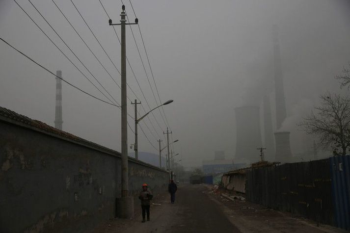 Kolaorkuver í Peking sést naumlega í gegnum mengunarmóðu. Helmingur allra kolaorkuvera heimsins eru í Kína.