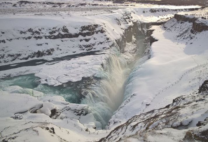 Flughált er við malargöngustíg niður að fossinum vegna vatnsúða sem breytist í ísbrynju.