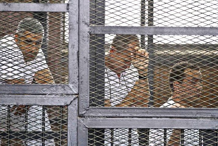 Fréttamennirnir Mohammed Fahmy, Peter Greste og Baher Mohammed í búri sakborninga.