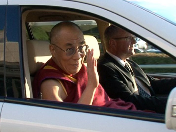 Dalai Lama heilsar í Leifsstöð í gærkvöldi.