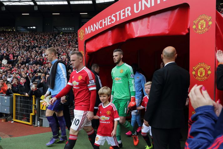 Wayne Rooney leiðir hér lið Manchester United inn á Old Trafford.