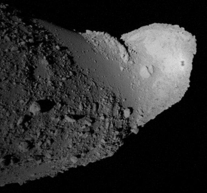 Ef rýnt er í myndina má sjá móðurfarið Hayabusa varpa skugga hægra megin á loftsteininum.