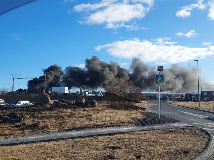 Mikinn svartan reyk bar frá eldinum í gær. Mikil mildi þykir að enginn hafi slasast þegar gaskútar þeyttust tugi metra frá nýbyggingunni.