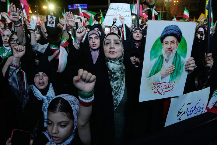 Stuðningsmenn klerkastjórnarinnar í Íran á samstöðufundi í Tehran á mánduaginn. Þarna má sjá fólk halda á myndum af Mojtaba Khamenei, æðstaklerk Íran.