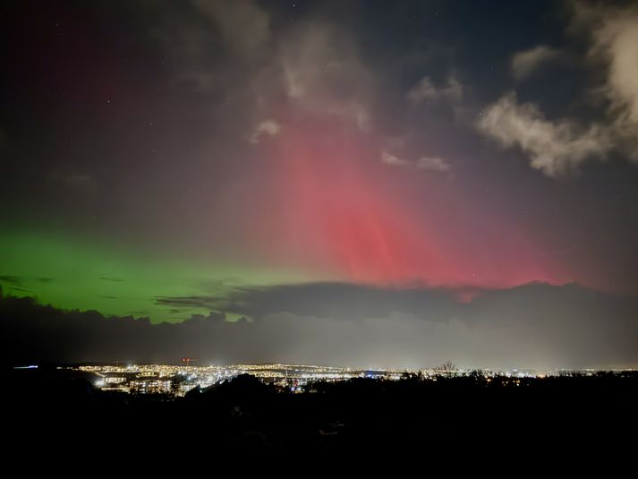 Rauð norðurljós eru yfir Reykjavík.