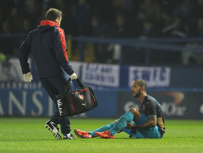 Walcott liggur meiddur á vellinum í gær.