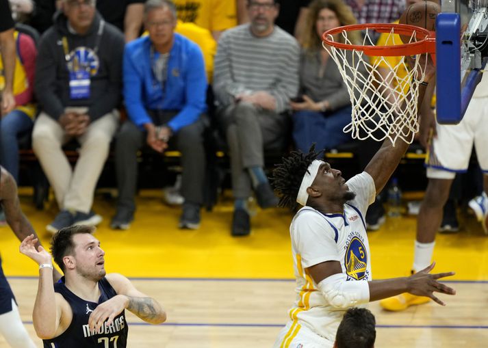 Kevon Looney, leikmaður Golden State Warriors, kemur boltanum ofan í körfuna á meðan Luka Doncic, leikmaður Dallas Mavericks, fylgist með.  