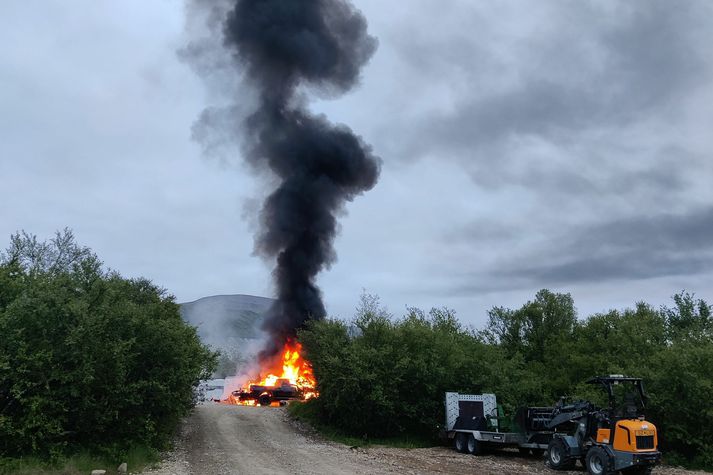 Hjólhýsið og bíll fólksins stóðu í ljósum logum í nótt.