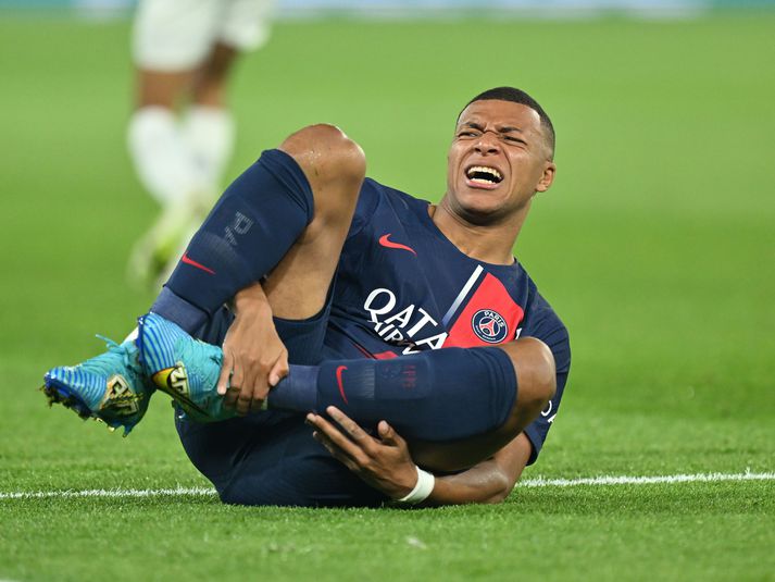 Mbappe liggur í grasinu í leiknum í kvöld.