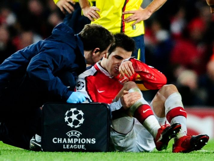 Cesc Fabregas liggur hér meiddur í grasinu.