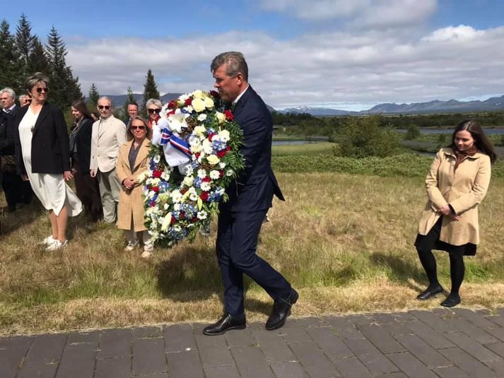 Bjarni Benediktsson ber blómsveig að minnisvarða um þáverandi forsætisráðherra og nafna, eiginkonu hans og barnabarn.