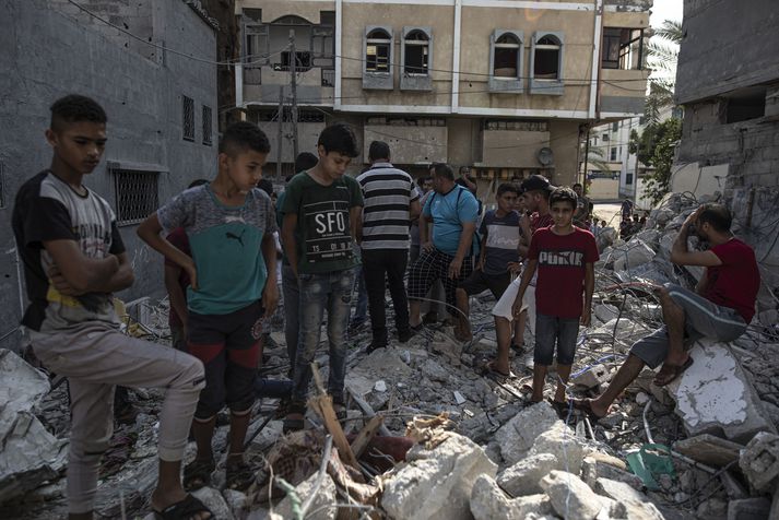 Palestínumenn leita í rústum hússins sem Ísraelar sprengdu í nótt.