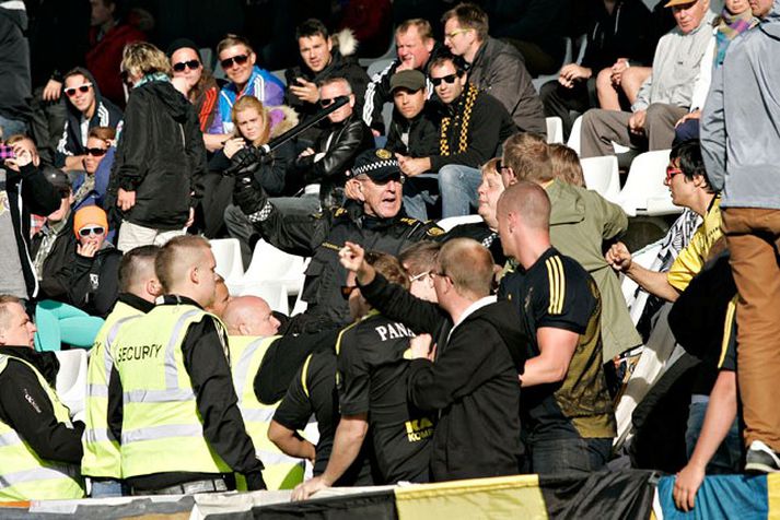 Eins og sést á þessari mynd þurfti lögreglumaður að beita kylfunni á stuðningsmenninga sem sungu látlaust allan leikinn.