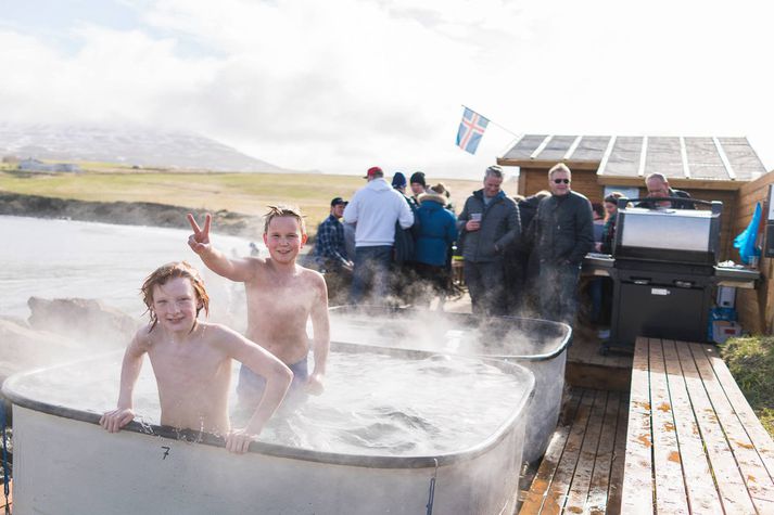 Börn að leik í heitu pottunum í Sandvíkurfjöru.