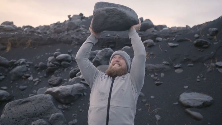 Kári Kristján Kristjánsson með stein á lofti í fjörunni.