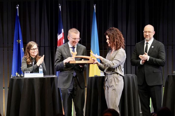 Þórdís afhendir utanríkisráðherra Lettlands hamarinn við lok Reykjavíkurfundarins í dag.