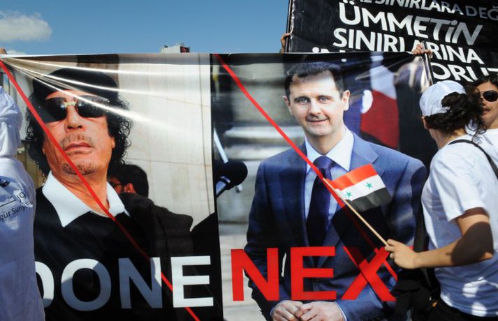 Aukinn kraftur færðist í mótmæli í Sýrlandi í dag. Hér halda mótmælendur uppi skilti með myndum af Bashar al-Assad, forseta Sýrlands og Gaddafi.