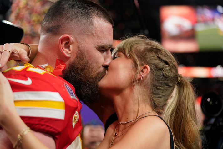 Taylor Swift kyssir Travis Kelce niðri á vellinum eftir sigur Kansas City Chiefs í Super Bowl.