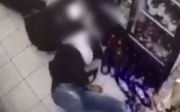 Upptaka öryggismyndavélar sýnir Charles liggjandi á gólfi verslunar í glímu við lögreglumann.