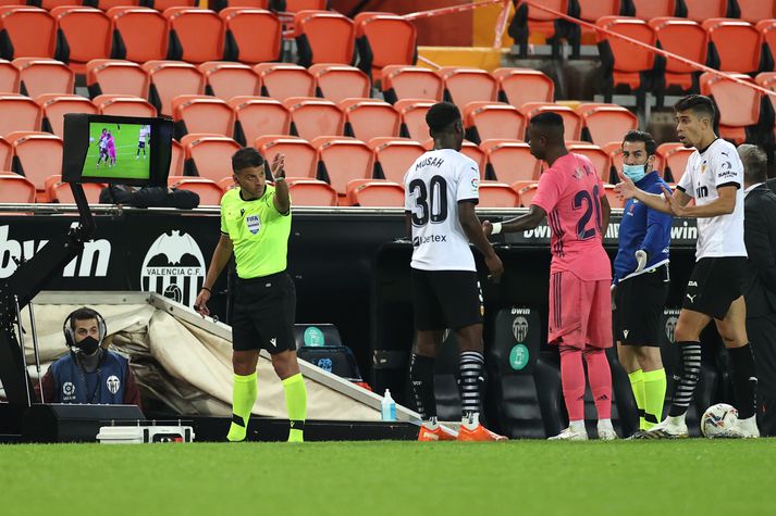 Jesús Gil Manzano dæmir þriðju vítaspyrnuna á Real Madrid gegn Valencia í spænsku úrvalsdeildinni í gær eftir að hafa kíkt á VAR-skjáinn á hliðarlínunni.