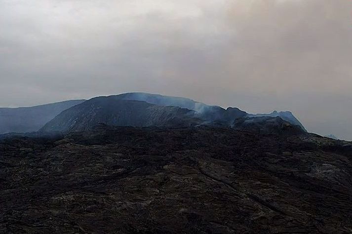 Gígurinn í Geldingadölum nú síðdegis. Enn rýkur upp úr gígnum þótt ekki sjáist til rennandi hrauns.