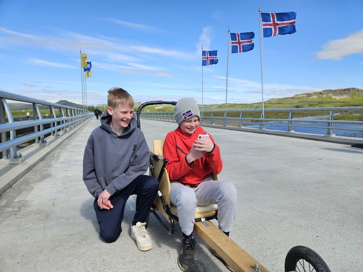 Félagarnir Hrafnkell Máni og Snorri á kassabílnum, sem þeir smíðuðu sjálfir. Snorri tekur hér á móti árnaðaróskum í símanum sínum.