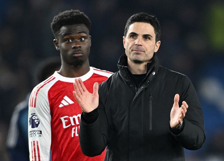 Mikel Arteta, knattspyrnustjóri Arsenal, fagnar sigri á Brighton & Hove Albion en fyrir aftan hann Bukayo Saka er sem skoraði sigurmarkið.