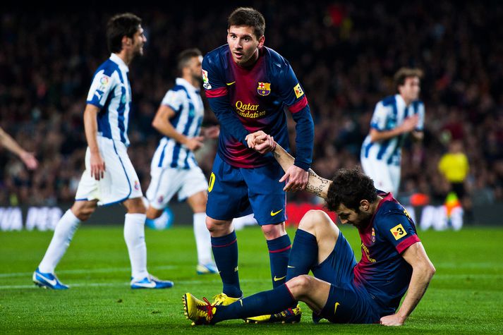 Lionel Messi hjálpar Cesc Fabregas á fætur.