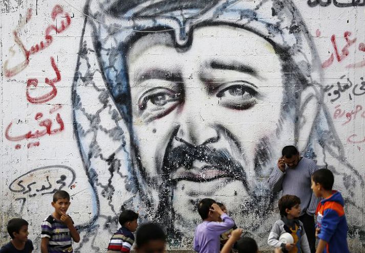 Palestínskir drengir virða fyrir sér mynd af Arafat sem teiknuð var upp á húsvegg.