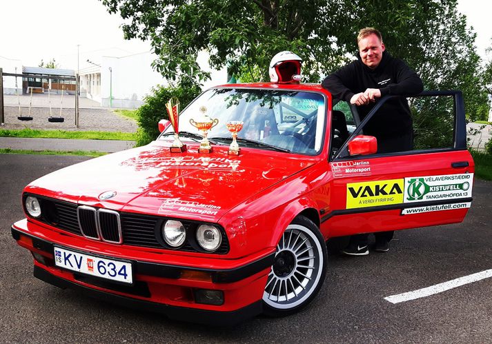 Aron Jarl við BMW bíl sinn og fagnar enn einum sigrinum.