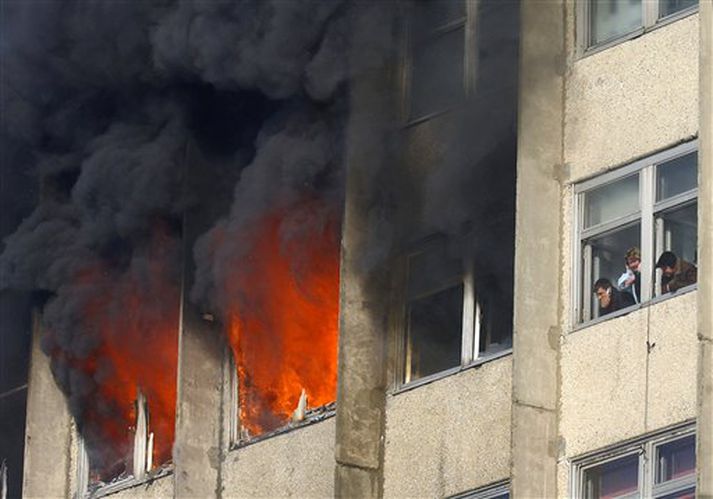 Fólk í skrifstofubyggingunni í Vladivostok bíður eftir að slökkvilið komi því til bjargar.