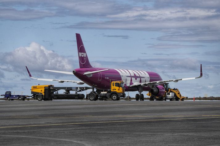 Flugvélin sem Isavia kyrrsetti vegna skuldar WOW air sést hér á Keflavíkurflugvelli í dag. Athygli vekur að flutningabílar eru staðsettir hringinn í kringum vélina.