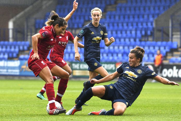 Amy Turner hjá Manchester United tæklar hér Courtney Sweetman-Kirk, leikmann Liverpool, í gær.