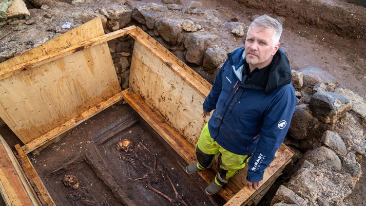 Hermann Jakob Hjartarson, fornleifafræðingur, stendur hér við leifar grafhýsisins. Þar liggja tvær beinagrindur sem líklega eru af mæðgum; stiftamtsmannsfrú og dóttur hennar.