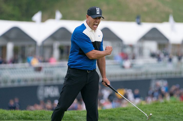 Koepka fagnar hér á átjándu flöt i gær þegar fuglapútt hans tryggði honum fjórða risatitilinn.