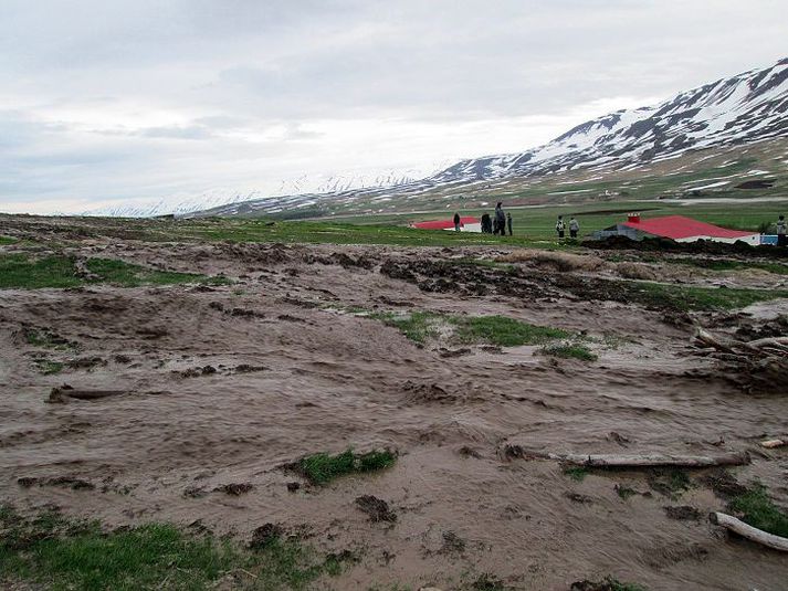 Heimamenn virða fyrir sér vegsummerki eftir hamfarirnar sem dundu á bænum Grund í Svarfaðardal eftir að krapastífla brast í Nykurtjörn.
